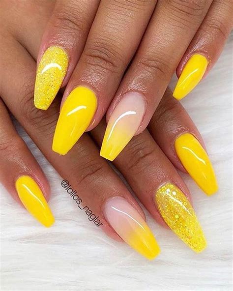 Yellow nail designs with glitter - Most of the nails are designed with a nude shade and are topped with some sunflower designs. The accent nail is a really thick French tip with a white to yellow ombré design. Lavender, pink, and yellow look so adorable together. These pink nails slowly blend into either a yellow or lavender shade. 